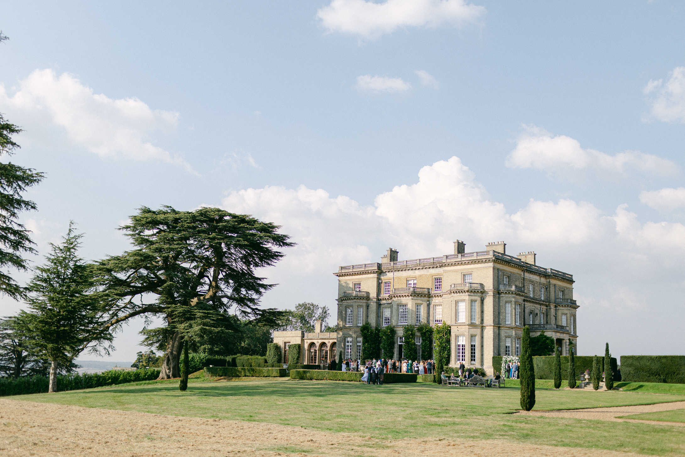 Hedsor House Wedding Venue in the sunshine with guests enjoying champagne in the gardens