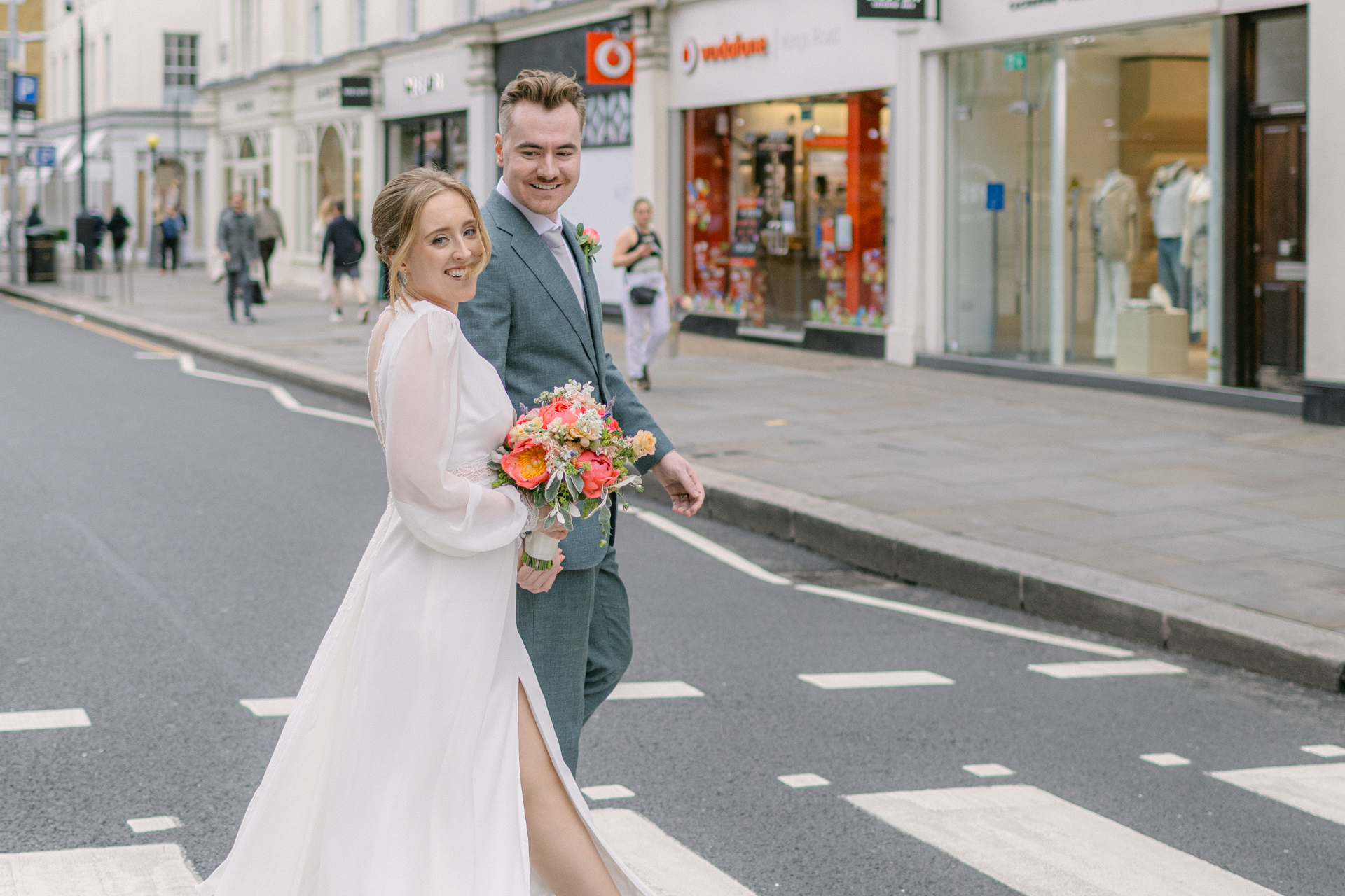 Bride and groom crossing King’s Road on a zebra crossing during their intimate Chelsea Town Hall micro wedding
